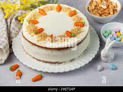 Gâteau aux carottes de Pâques fait maison avec des noix, glacé avec du fromage à la crème. Dessert sucré. Assiette avec délicieux gâteau aux carottes Banque D'Images