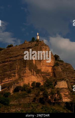 Statue du Christ Rédempteur, érigée en 1950 au sommet d'un rocher, la Peña del Morral, au-dessus du village de Graus, dans le comté de Ribagorça ou Ribagorza, province de Huesca, Aragon, Espagne. La statue est connue sous le nom de Christ Rédempteur de la Ribagorza (El Cristo Redentor de la Ribagorza) et Monument au Sacré-cœur. Banque D'Images