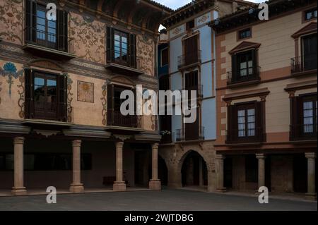 Maisons sur la place principale, Plaza Mayor ou Plaza de España, à Graus, un village dans Ribagorça ou Ribagorza comté, province de Huesca, Aragon, Espagne. Sur la gauche se trouve la façade décorée de la Casa Heredia, une grande maison-palais construite au milieu des années 1700 La plupart des décorations peintes, y compris les marécages floraux bleus au premier étage et les motifs végétaux au deuxième étage, ont été ajoutés à la façade en 1828. Le cadran solaire a été ajouté en 1939. Banque D'Images