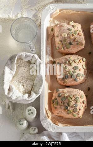 Brioches dorées aux graines de citrouille à base de farine et de levain. Petits pains cuits dans une boulangerie. Banque D'Images