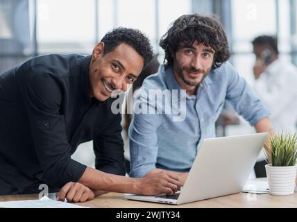 Professionnels d'affaires collaborant joyeusement dans un bureau moderne avec la technologie. Banque D'Images