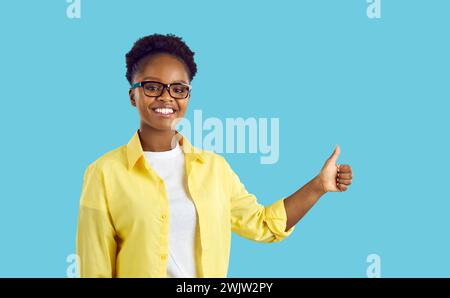Femme heureuse faisant signe pouce vers le haut et souriant joyeusement, montrant son soutien et son respect pour vous. Banque D'Images