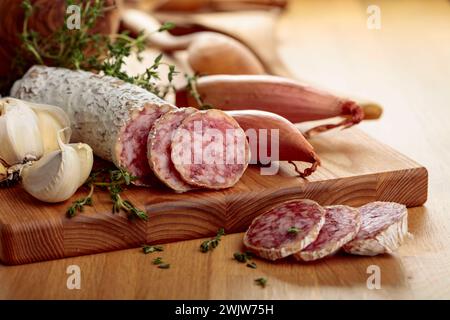 Saucisse traditionnelle séchée au thym, à l'ail et à l'oignon. Saucisse sèche sur une table en bois. Banque D'Images