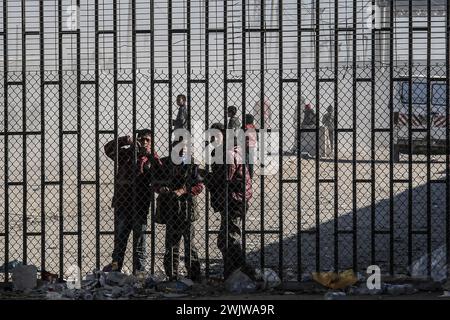 Rafah, Territoires palestiniens. 17 février 2024. Des enfants palestiniens se tiennent derrière une clôture près du poste frontière de Kerem Shalom, où des camions chargés d'aide internationale sont entrés à Gaza. Crédit : Abed Rahim Khatib/dpa/Alamy Live News Banque D'Images