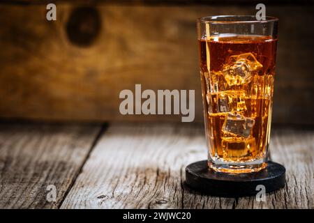 Thé glacé avec beaucoup de glace en verre transparent sur table en bois rustique Banque D'Images