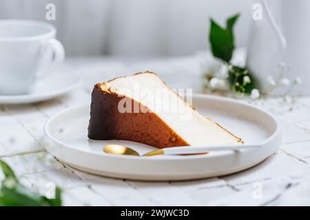 Dessert espagnol populaire appelé Saint-Sébastien cheesecake. Gâteau au fromage brûlé basque classique. Un morceau de gâteau sur fond blanc Banque D'Images