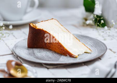 Dessert espagnol populaire appelé Saint-Sébastien cheesecake. Gâteau au fromage brûlé basque classique. Un morceau de gâteau sur fond blanc Banque D'Images