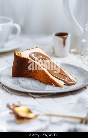 Dessert espagnol populaire appelé Saint-Sébastien cheesecake. gâteau au fromage brûlé basque. Un morceau de gâteau sur fond blanc avec glaçage au chocolat dessus. Banque D'Images