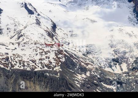 Hélicoptère survolant les Alpes suisses enneigées en Suisse Banque D'Images
