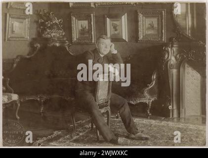 Benoit constant dit Coquelin aîné (1841-1909), acteur français, dans son intérieur. Photographie de Paul Cardon (dit Dornac ou Paul Marsan). Tirage de papier albumine. Entre 1885 et 1895. Paris, musée Carnavalet. Acteur, assis, califourchon, maison, français, intérieur, portrait, salon, scène intérieure, 19ème 19ème XIX 19ème 19ème siècle Banque D'Images