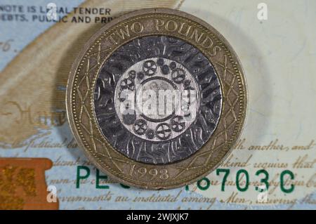 Des dollars américains et deux livres sterling britanniques avec la reine Elizabeth ii sur l'avers et quatre cercles concentriques pour l'âge du fer, Industrial Revo Banque D'Images