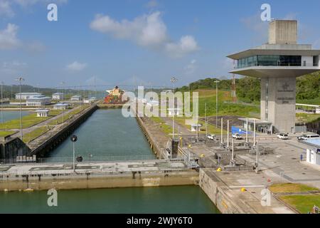 Colon, Panama - 23 janvier 2024 : écluses et tour de contrôle d'Agua Clara sur le canal de Panama. La porte de serrure en acier lourd au premier plan est fermée. Banque D'Images