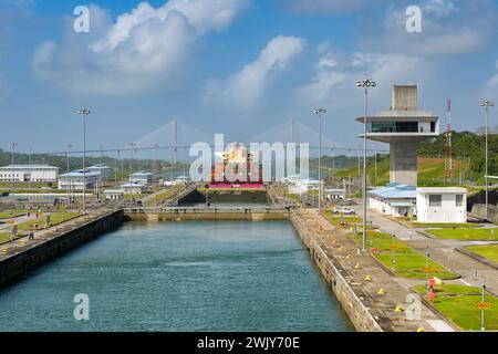 Colon, Panama - 23 janvier 2024 : écluses et tour de contrôle d'Agua Clara sur le canal de Panama. À l'arrière-plan, il y a un porte-conteneurs et le pont de l'Atlantique Banque D'Images