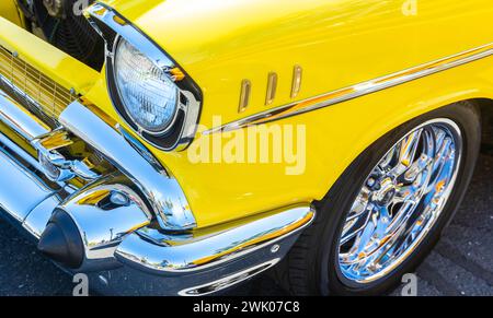 Gros plan du phare d'une voiture jaune classique restaurée sur mesure avec chrome Banque D'Images