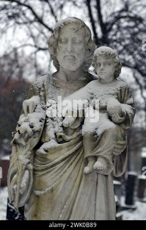 Sculpture enneigée de Jésus au cimetière historique notre-Dame-des-Neiges de Montréal, le plus grand au Canada. Banque D'Images