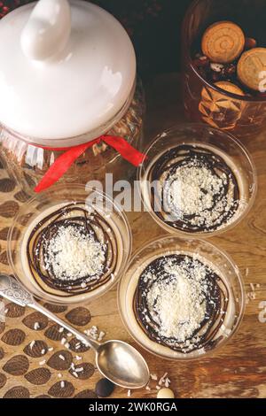 Panna cotta italienne dessert avec garniture au chocolat. Panna cotta décorée avec du chocolat blanc sur fond de bois vintage. Banque D'Images