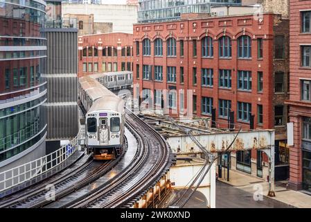 Train de banlieue surélevé de Chicago sur des voies sinueuses dans le centre-ville par un jour de printemps pluvieux Banque D'Images