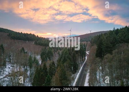 Une route enneigée sinueuse à travers une colline boisée Banque D'Images