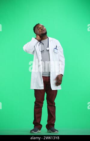 Le médecin, en pleine hauteur, sur fond vert, fatigué Banque D'Images