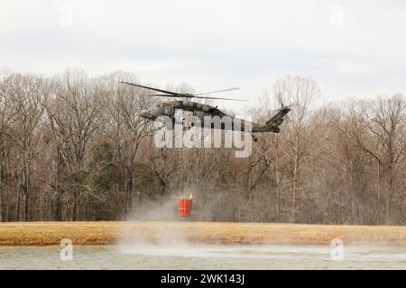 Les membres du 1/230th Assault Helicopter Battalion de la Garde nationale du Tennessee s'entraînent avec le département des forêts du Tennessee pour pratiquer des techniques aériennes de lutte contre les incendies, sur le site d'entraînement des volontaires de Milan, le 8 février. Les gardiens ont utilisé des hélicoptères UH-60 Blackhawk équipés de bambi Buckets pour faire tomber de l'eau sur des cibles flamboyantes, tandis que le personnel du département des forêts les dirigeait depuis le sol. (Photo de la Garde nationale de l'armée américaine par le sergent de 1re classe Timothy Cordeiro). Banque D'Images