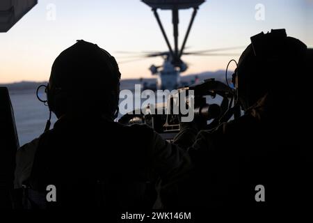 U.S. Marine corps Sgts. Wyatt Henson, à droite, et Johann Cardona, chefs d'équipage du Marine Heavy Helicopter Squadron (HMH) 465, Marine Aircraft Group 16, 3rd Marine Aircraft Wing, préparent le décollage avec une équipe de pompiers du 1st Marine reconnaissance Battalion, 1st Marine Division, au cours de l'exercice distribué de la Marine Air-Ground Task Force (MDMX) au Marine corps Air-Ground combat Center, Twentynine Palms, Californie, le 10 février 2024. Les Marines avec 1st Recon ont commencé MDMX en effectuant une insertion tactique de nuit dans un environnement austère. MDMX est un exercice de manœuvre qui intègre le sol, l'air, un Banque D'Images