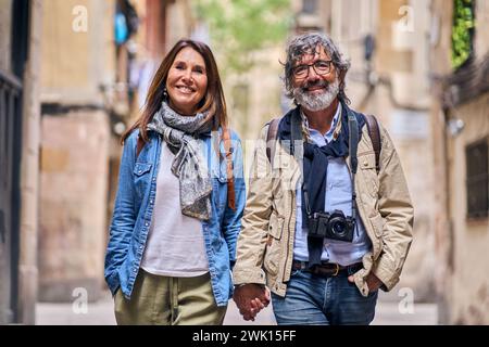 Portrait heureux couple caucasien senior marchant la main à l'extérieur. Les touristes mûrs amoureux Banque D'Images