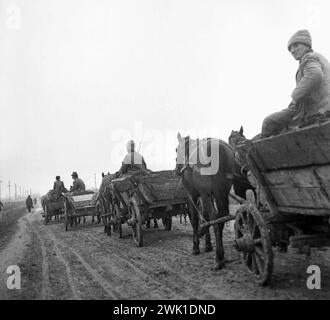 République socialiste de Roumanie, approx. 1976. Paysans dans des wagons tirés par des chevaux sur une route de campagne boueuse. Banque D'Images