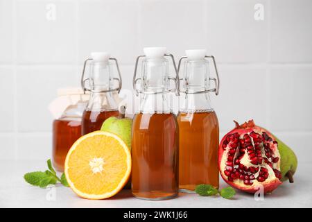 Savoureux kombucha, fruits frais et menthe sur table blanche Banque D'Images