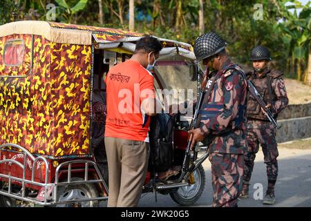 Bandarban, Bangladesh. 13 février 2024. Des membres du BGB contrôlent des civils dans la région de Naikhongchori, près de la frontière entre le Bangladesh et le Myanmar, dans le district de Bandarban au Bangladesh. Le conflit entre le BGP et l'armée d'Arakan, un groupe rebelle armé à l'intérieur du Myanmar, se poursuit sans relâche. Des tirs soutenus, le bruit des obus de mortier éclatant a pu être entendu à travers la zone frontalière entre le Bangladesh et le Myanmar. Des balles et des obus de mortier tirés depuis le Myanmar traversent la frontière dans les villes du Bangladesh. Crédit : SOPA images Limited/Alamy Live News Banque D'Images