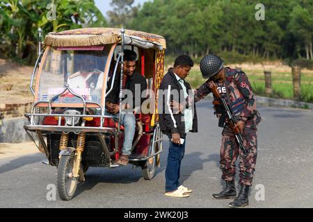 Bandarban, Bangladesh. 13 février 2024. Un membre du BGB a vu un civil en train de vérifier dans la région de Naikhongchori, près de la frontière entre le Bangladesh et le Myanmar, dans le district de Bandarban au Bangladesh. Le conflit entre le BGP et l'armée d'Arakan, un groupe rebelle armé à l'intérieur du Myanmar, se poursuit sans relâche. Des tirs soutenus, le bruit des obus de mortier éclatant a pu être entendu à travers la zone frontalière entre le Bangladesh et le Myanmar. Des balles et des obus de mortier tirés depuis le Myanmar traversent la frontière dans les villes du Bangladesh. Crédit : SOPA images Limited/Alamy Live News Banque D'Images