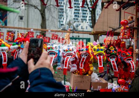 Un homme prend une photo de petits dragons dans l'un des étals du marché. Les danseurs de lion et de dragon défilent dans les rues de Rotterdam pour bénir les entrepreneurs du nouvel an. La cérémonie de danse du lion assure que les mauvais esprits sont chassés et apporte la prospérité et le bonheur pour la nouvelle année. Les communautés chinoises du monde entier ont accueilli mardi l'année du Dragon, inaugurant le nouvel an lunaire avec des prières, des fêtes familiales et des courses. C'est un festival annuel de 15 jours qui commence avec la nouvelle lune entre le 21 janvier et le 20 février dans les calendriers occidentaux. (Photo de Ana Fernandez / Banque D'Images