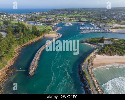 Vue aérienne d'une rivière qui coule en mer entre des brise-lames rocheux à Bermagui sur la côte sud de la Nouvelle-Galles du Sud en Australie. Banque D'Images