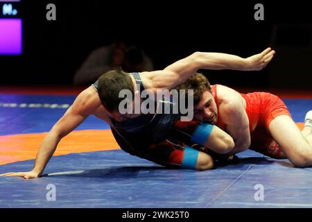 Bucarest, Roumanie. 17 février 2024. Arsen Harutunyan (R) d'Arménie concourt contre Muhammet Karavus de T¨¹rkiye dans la finale de la catégorie 57kg de lutte libre masculine aux Championnats d'Europe de lutte à Bucarest, Roumanie, le 17 février 2024. Crédit : Cristian Cristel/Xinhua/Alamy Live News Banque D'Images