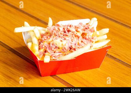 Aranda de Duero, Espagne - 17 septembre 2023 : garnir les frites de bacon et de fromage. Banque D'Images