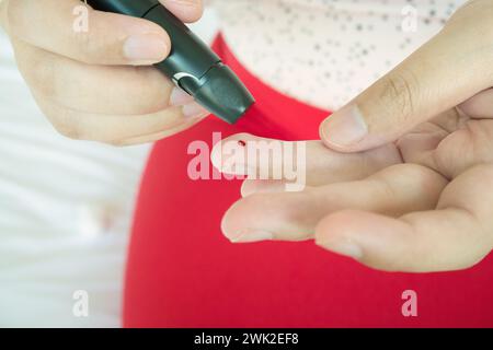 Femme à l'aide d'amphioxus sur doigt, test du diabète contrôler le niveau de sucre dans le sang Banque D'Images