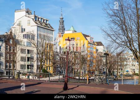 Bâtiments résidentiels modernes colorés le long du canal avec la tour du Zuiderkerk dans le centre d'Amsterdam en arrière-plan. Banque D'Images