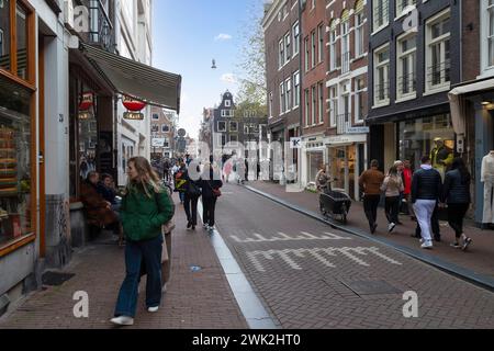 Résidents et touristes flânent dans les rues commerçantes étroites du centre d'Amsterdam. Banque D'Images