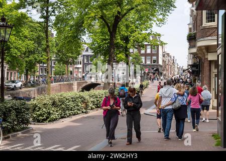 Résidents et touristes marchent dans les rues étroites d'Amsterdam. Banque D'Images