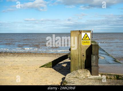 Panneau d'avertissement sur une jetée de béton sur la plage de Mundesley, côte de Norfolk Banque D'Images