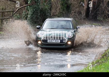 Eton, Windsor, Royaume-Uni. 18 février 2024. Automobilistes conduisant à travers les eaux de crue sur un pays à Eton, Windsor, Berkshire après de fortes pluies nocturnes. Crédit : Maureen McLean/Alamy Live News Banque D'Images