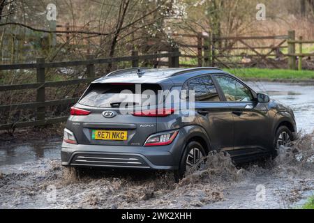 Eton, Windsor, Royaume-Uni. 18 février 2024. Automobilistes conduisant à travers les eaux de crue sur un pays à Eton, Windsor, Berkshire après de fortes pluies nocturnes. Crédit : Maureen McLean/Alamy Live News Banque D'Images
