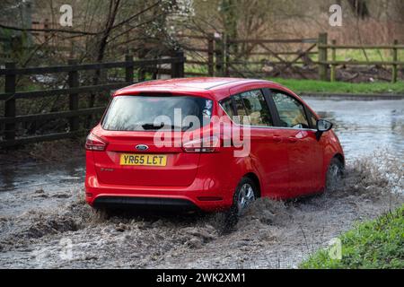 Eton, Windsor, Royaume-Uni. 18 février 2024. Automobilistes conduisant à travers les eaux de crue sur un pays à Eton, Windsor, Berkshire après de fortes pluies nocturnes. Crédit : Maureen McLean/Alamy Live News Banque D'Images