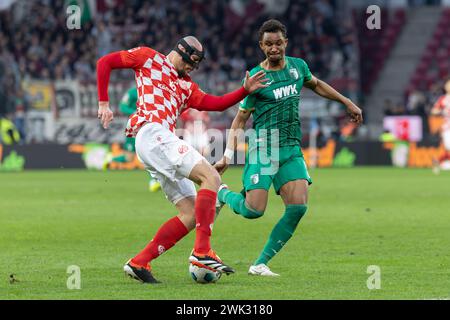Mainz, Allemagne. 17 février 2024. Football : Bundesliga, FSV Mainz 05 - FC Augsburg, Journée 22, Mewa Arena. Duel entre Ludovic Ajorque (1.FSV Mainz 05, 17) et Felix Uduokhai (FC Augsburg, 19). Crédit : Jürgen Kessler/dpa - REMARQUE IMPORTANTE: conformément aux règlements de la DFL German Football League et de la DFB German Football Association, il est interdit d'utiliser ou de faire utiliser des photographies prises dans le stade et/ou du match sous forme d'images séquentielles et/ou de séries de photos de type vidéo./dpa/Alamy Live News Banque D'Images