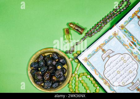 Livre musulman ouvert avec calligraphie arabe Coran traduction : livre Saint des musulmans et oud parfum et censeur, dates fruits, tasbih. iftar ramadan conce Banque D'Images