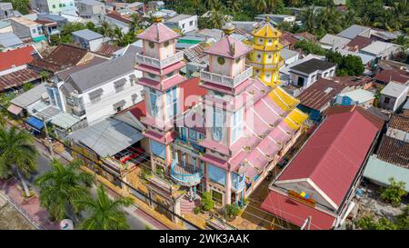 Sa Đéc, Vietnam. 18 février 2024 : vue aérienne d'un temple Cao Đài où sont pratiquées les cérémonies et les prières des fidèles du Caodaïsme. Cette religion syncrétique monothéiste vietnamienne, revendiquant 5 millions de croyants dans le monde entier, a célébré la Grande cérémonie de l’être suprême en l’année du Dragon 2024, comme chaque année le 8/9ème jour du premier mois lunaire. C’est l’un des rituels les plus importants de l’église Cao Dai. Basé sur les pratiques occultes du taoïsme, ce culte célébrera son 100e anniversaire officiel en 2026. Crédit : Kevin Izorce/Alamy Live News Banque D'Images