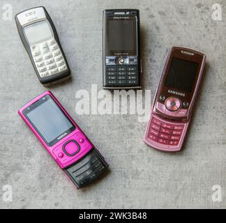 Collection vintage de vieux téléphones mobiles de différentes marques sur un fond concret Banque D'Images