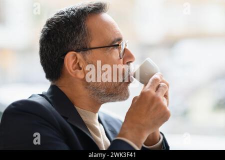 Homme d'affaires mûr avec les cheveux gris et la barbe, portant des lunettes et un costume sombre Banque D'Images
