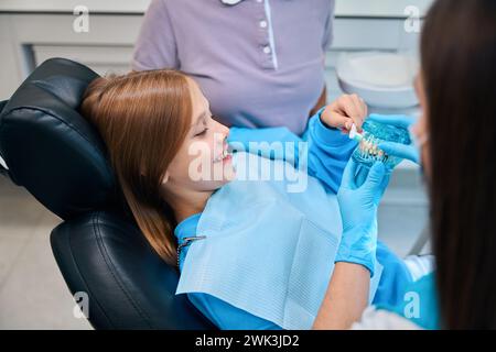 Fille tient le modèle de dentition et brosse à dents dans ses mains Banque D'Images