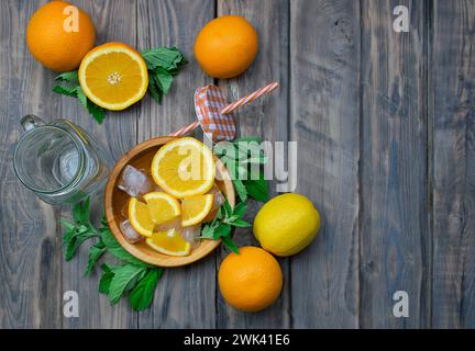 Préparation de boissons rafraîchissantes aux fruits d'été. Agrumes et herbes aromatiques sur une table en bois. Le concept d'alimentation saine et de désintoxication. Vitamines Banque D'Images