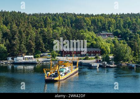 Vaxholm, Suède - 13 juin 2023 : ferry jaune avec des voitures dans l'archipel de Stockholm. Banque D'Images